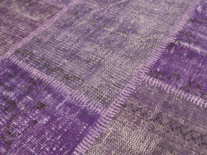 Gros plan sur les détails du textile et des motifs du tapis patchwork recyclé laine et coton violet