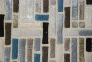 Groot vloerkleed met geometrische patronen, gemaakt van Nieuw-Zeelandse wol en viscose.